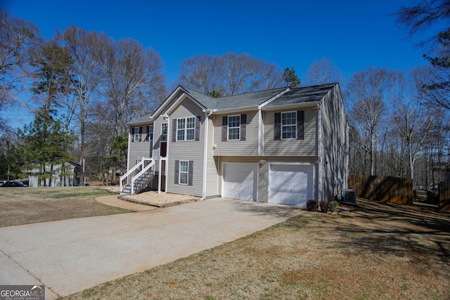 view of front of home with a garage, a front yard, and central air condition unit