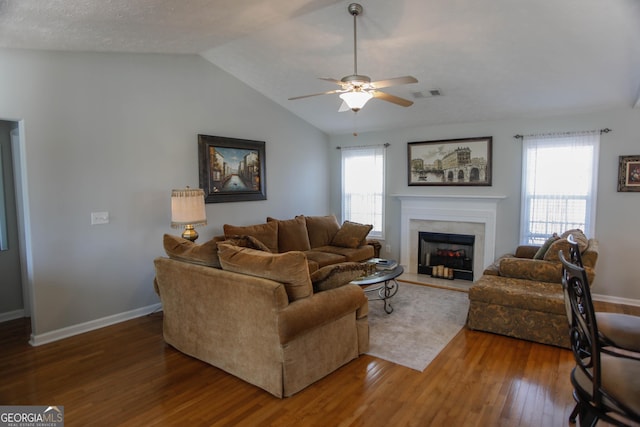 living room with vaulted ceiling, a healthy amount of sunlight, dark wood-type flooring, and french doors