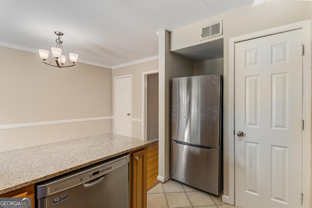 kitchen with light tile patterned floors, stainless steel appliances, pendant lighting, and crown molding