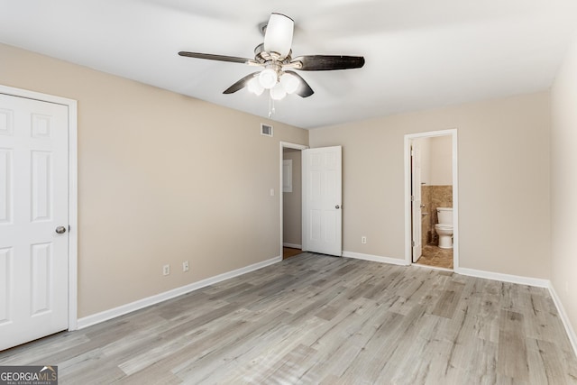 unfurnished bedroom with ceiling fan, light wood-type flooring, and connected bathroom