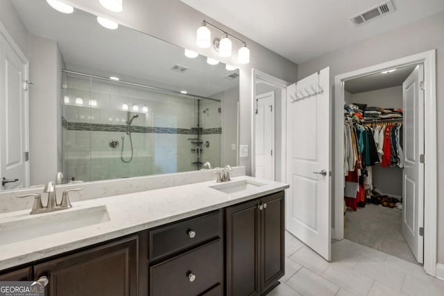 bathroom with tile patterned flooring, vanity, and a shower with door