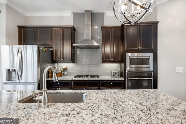 kitchen with wall chimney exhaust hood, stainless steel appliances, decorative backsplash, crown molding, and sink