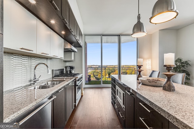 kitchen with white cabinetry, light stone countertops, sink, tasteful backsplash, and appliances with stainless steel finishes