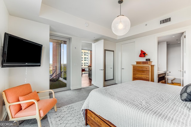 bedroom with a raised ceiling, access to exterior, and carpet floors