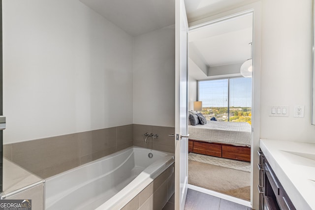 bathroom featuring vanity and tiled tub