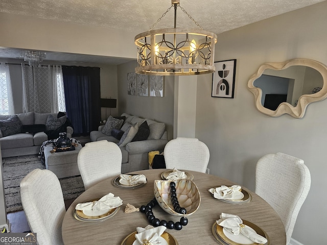 dining space with a textured ceiling and a chandelier