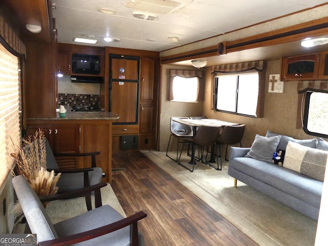 interior space with dark wood-type flooring and black microwave