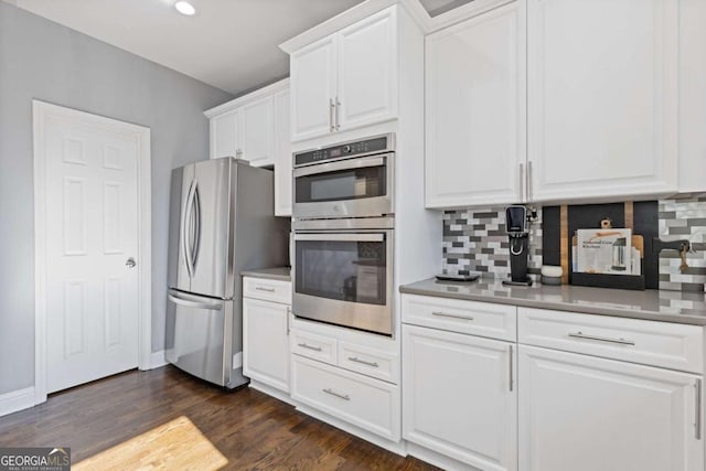 1331 Dayspring Trce, Lawrenceville, GA 30045 - kitchen with dark hardwood / wood-style flooring, appliances with stainless steel finishes, white cabinets, and backsplash