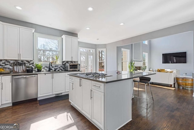 1331 Dayspring Trce, Lawrenceville, GA 30045 - kitchen with a breakfast bar, appliances with stainless steel finishes, a center island, and white cabinets