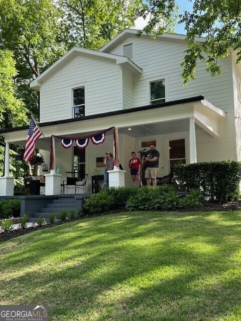 view of front facade with a front yard and covered porch