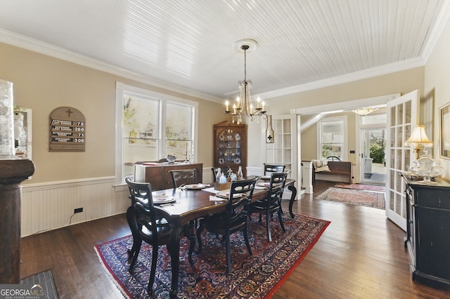 dining room featuring ornamental molding, wainscoting, dark wood finished floors, and an inviting chandelier