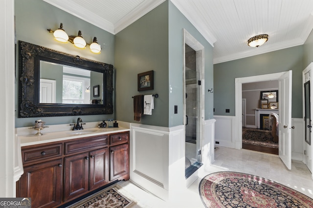 bathroom with ornamental molding, a fireplace, a shower stall, and vanity