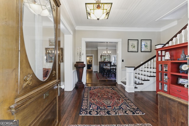 entrance foyer with wainscoting, hardwood / wood-style flooring, stairs, crown molding, and a notable chandelier