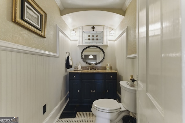 bathroom featuring toilet, wainscoting, tile patterned flooring, and vanity