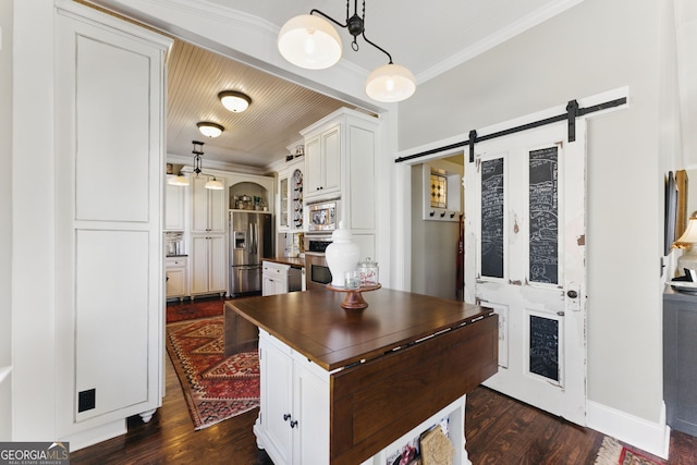 kitchen featuring appliances with stainless steel finishes, dark countertops, ornamental molding, and a barn door