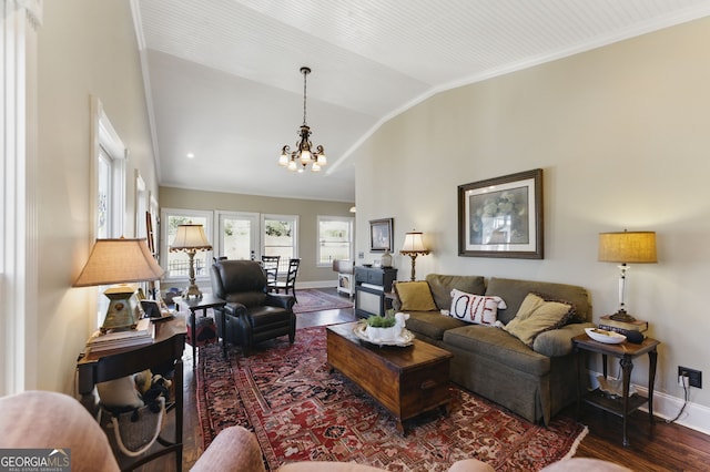 living room featuring lofted ceiling, baseboards, crown molding, and wood finished floors