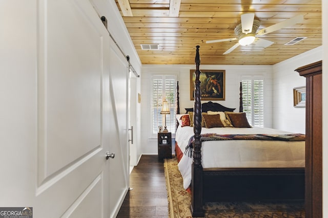 bedroom featuring wood ceiling, dark wood-style floors, a barn door, and visible vents