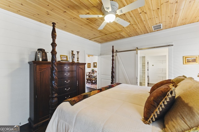 bedroom with wood ceiling, a barn door, visible vents, and ceiling fan