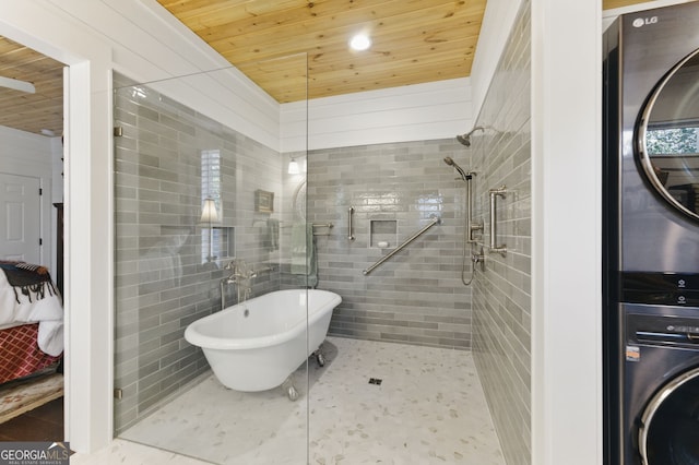 bathroom with stacked washer and dryer, wood ceiling, tile patterned flooring, a freestanding tub, and tiled shower