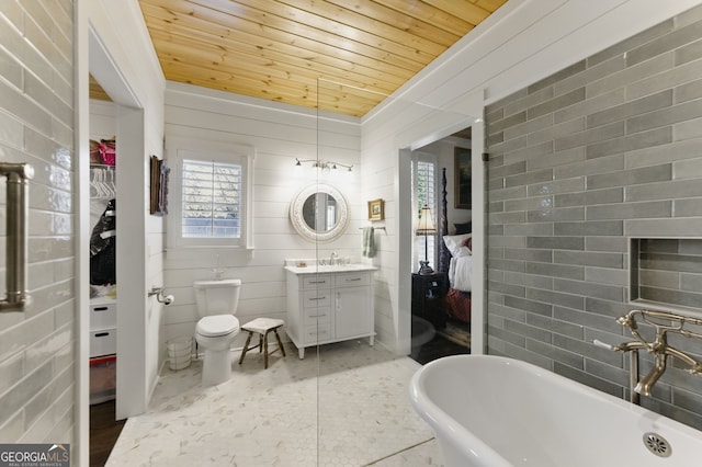 bathroom featuring ensuite bathroom, toilet, vanity, wood ceiling, and a freestanding bath