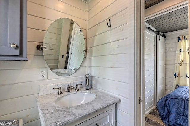 bathroom with sink and wood walls