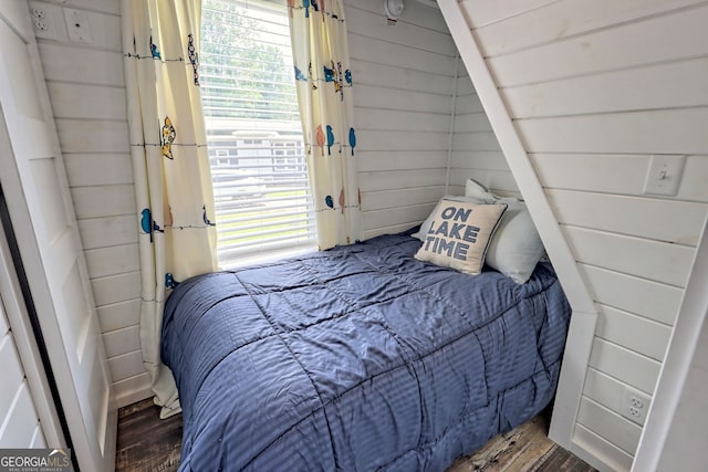 bedroom featuring hardwood / wood-style floors and wood walls