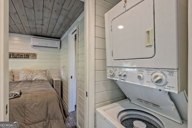 laundry area featuring wood ceiling, stacked washer / drying machine, a wall unit AC, and wood walls