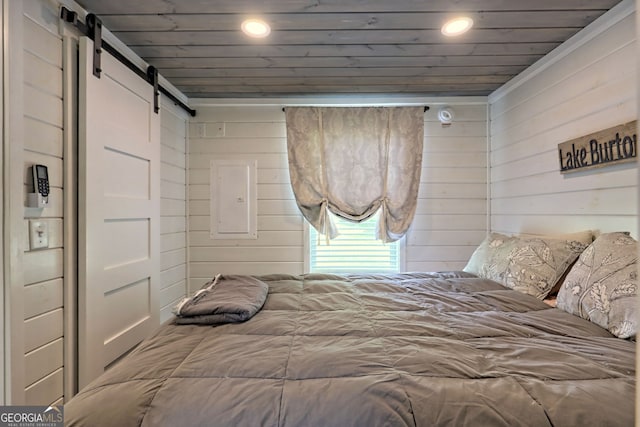 bedroom with a barn door, wooden walls, and wood ceiling