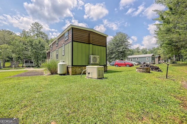 view of outdoor structure with ac unit and a lawn