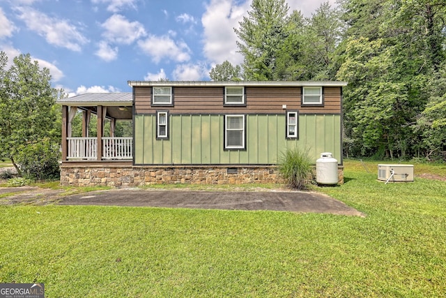 back of property featuring a porch and a yard