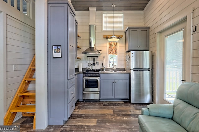 kitchen featuring appliances with stainless steel finishes, decorative light fixtures, sink, gray cabinetry, and wall chimney exhaust hood