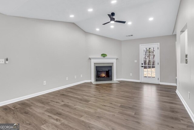 unfurnished living room featuring lofted ceiling, hardwood / wood-style floors, and ceiling fan