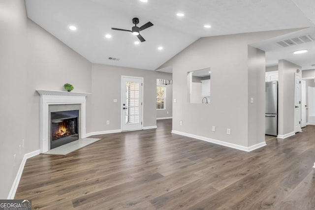 unfurnished living room with hardwood / wood-style flooring, ceiling fan, and vaulted ceiling