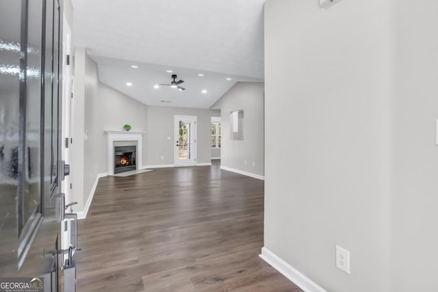 unfurnished living room with dark wood-type flooring, a textured ceiling, and ceiling fan