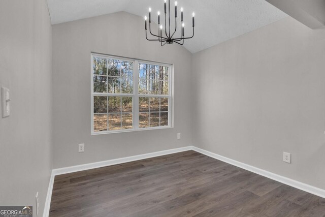 unfurnished dining area with lofted ceiling, dark hardwood / wood-style floors, and an inviting chandelier