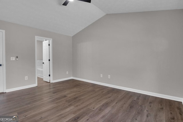 spare room with ceiling fan, dark hardwood / wood-style flooring, vaulted ceiling, and a textured ceiling