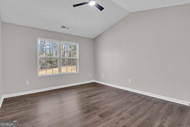 unfurnished bedroom featuring vaulted ceiling, dark wood-type flooring, connected bathroom, and ceiling fan