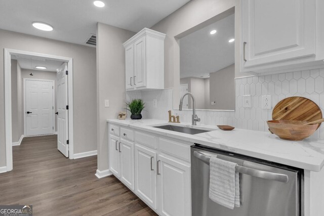 kitchen with sink, stainless steel dishwasher, dark hardwood / wood-style floors, light stone countertops, and white cabinets