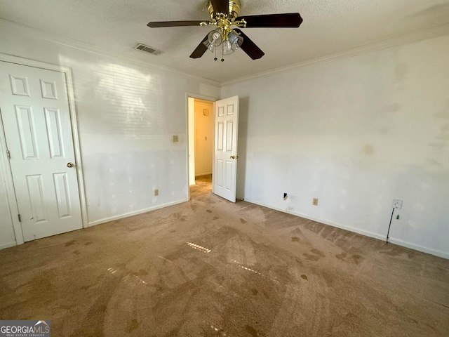 unfurnished bedroom with crown molding, light colored carpet, ceiling fan, and a textured ceiling