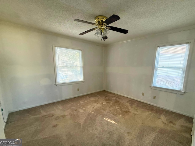 carpeted empty room with ceiling fan and a textured ceiling