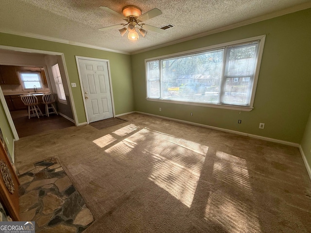 unfurnished bedroom featuring multiple windows, ornamental molding, carpet floors, and a textured ceiling