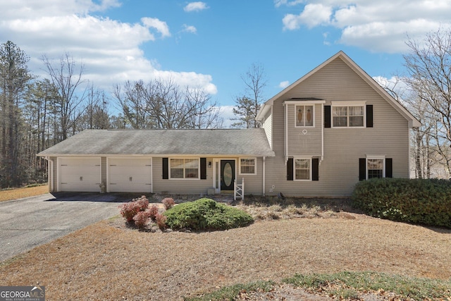 traditional home with a garage and aphalt driveway