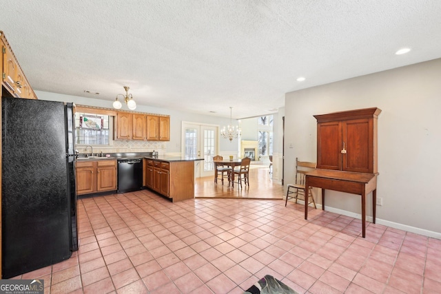 kitchen featuring a notable chandelier, black appliances, plenty of natural light, and pendant lighting