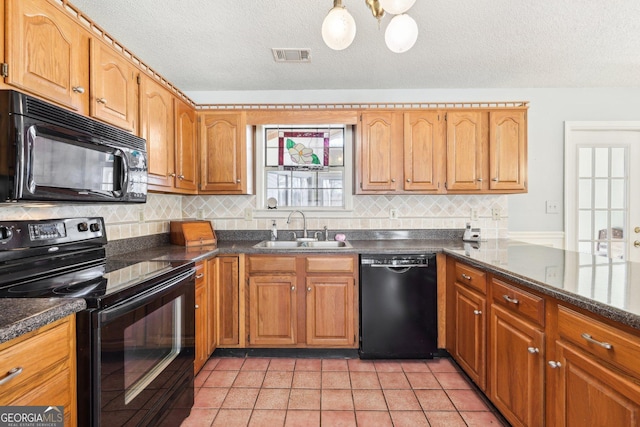 kitchen featuring visible vents, brown cabinetry, light tile patterned flooring, a sink, and black appliances