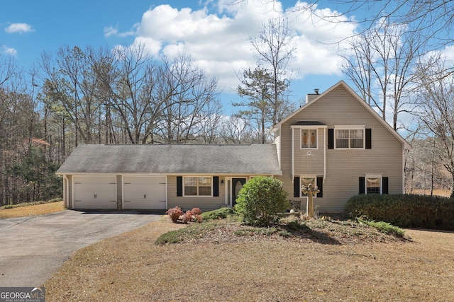 traditional-style home featuring aphalt driveway, a front yard, a chimney, and a garage