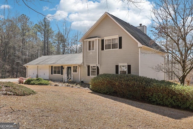 traditional-style home with an attached garage and a chimney