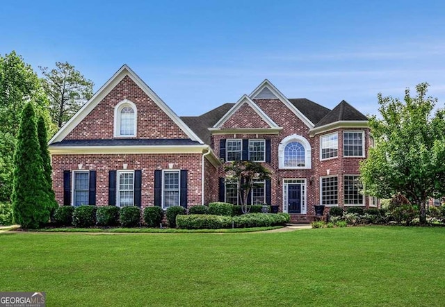 view of front of property featuring a front yard and brick siding