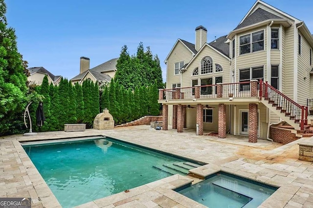 outdoor pool featuring stairway, a deck, a patio, and an in ground hot tub