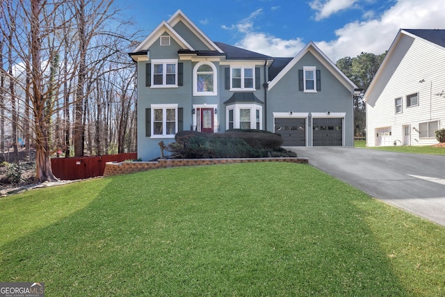 view of front of property featuring an attached garage, driveway, a front lawn, and stucco siding