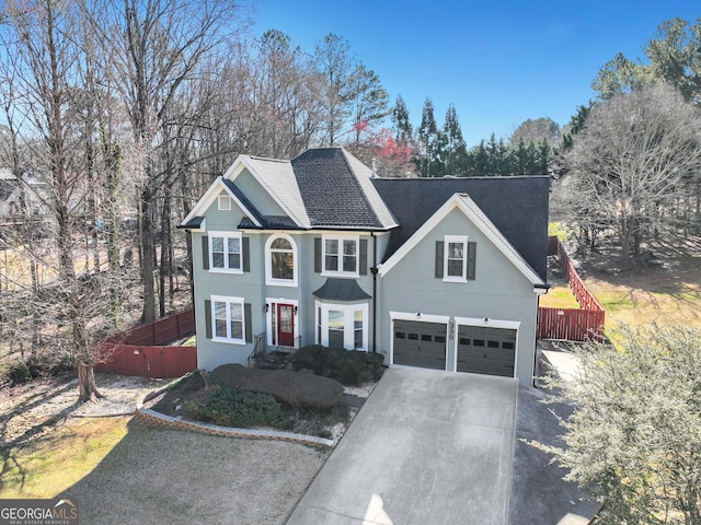 view of front of house with driveway, stucco siding, and roof with shingles